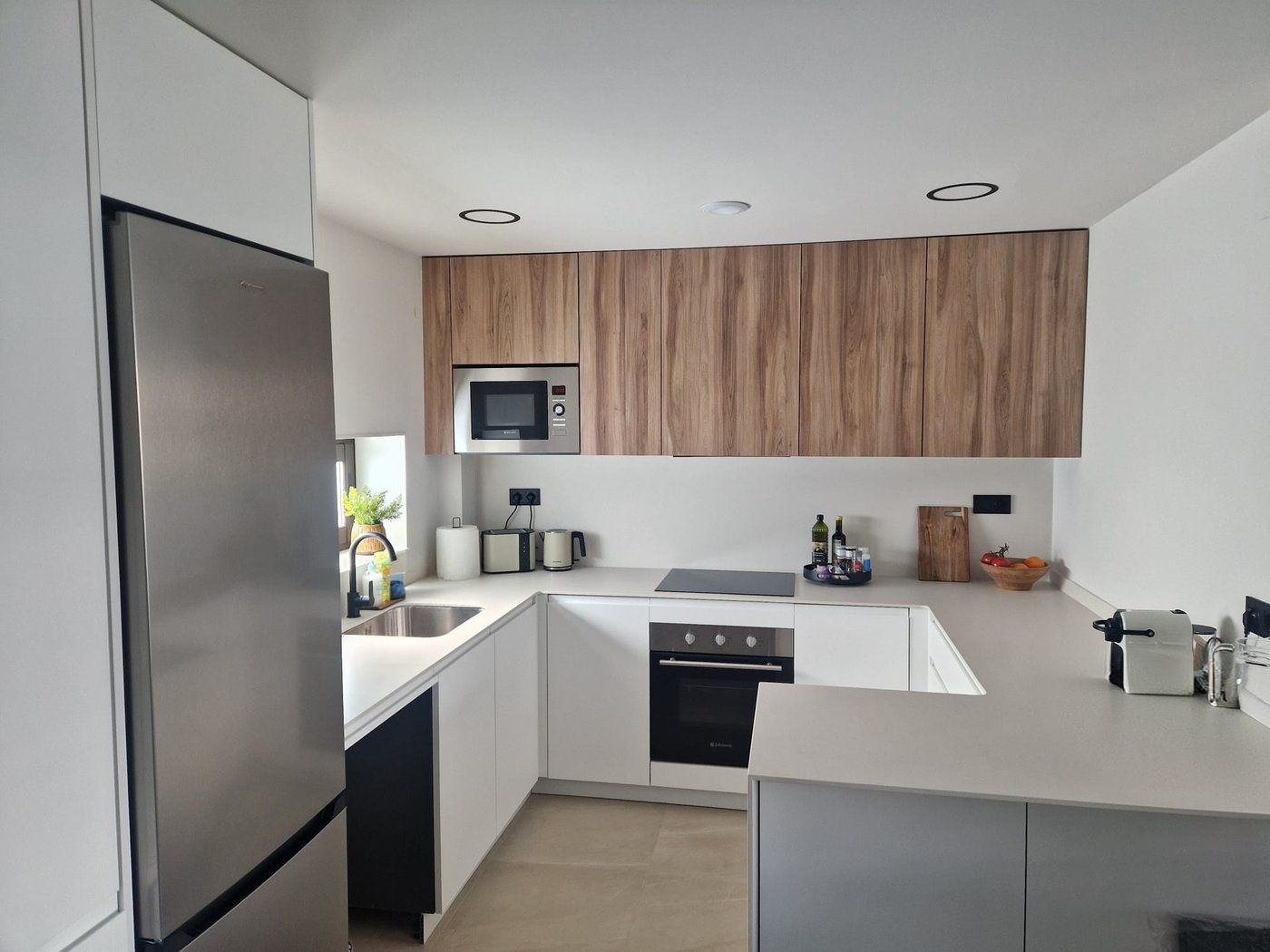 Open keuken met inductiekookplaat, oven en magnetron