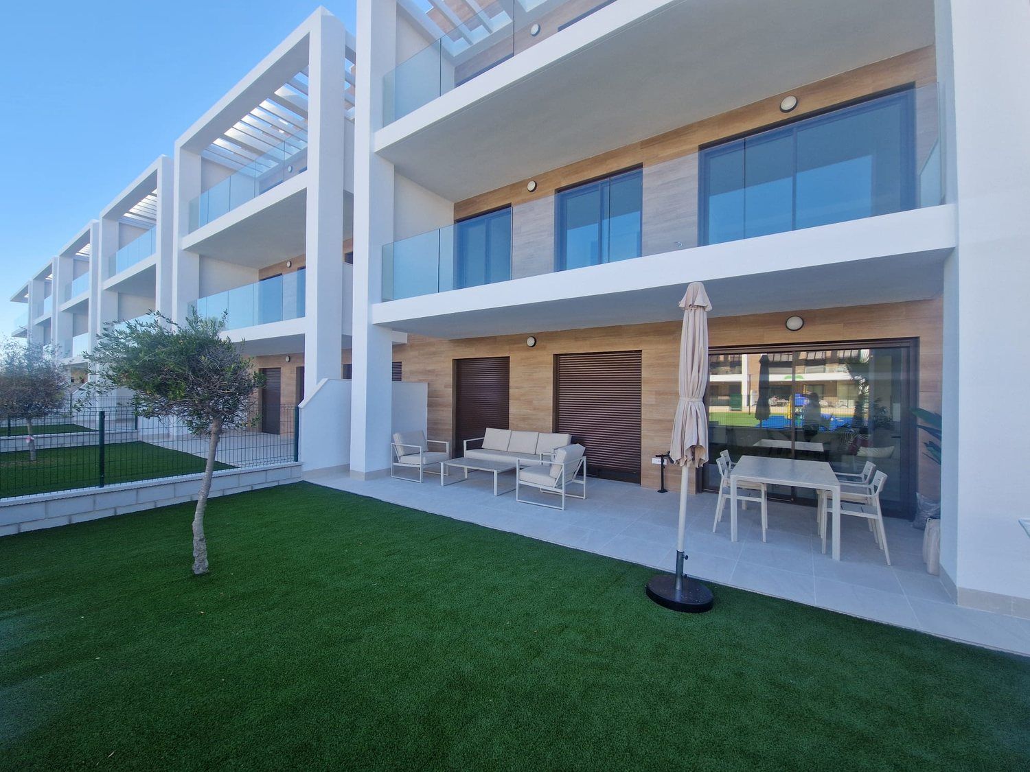 Privé terras met tuin, loungeset en parasol
